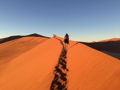 A GVSU study abroad students walks on a sand dune in Namibia Africa